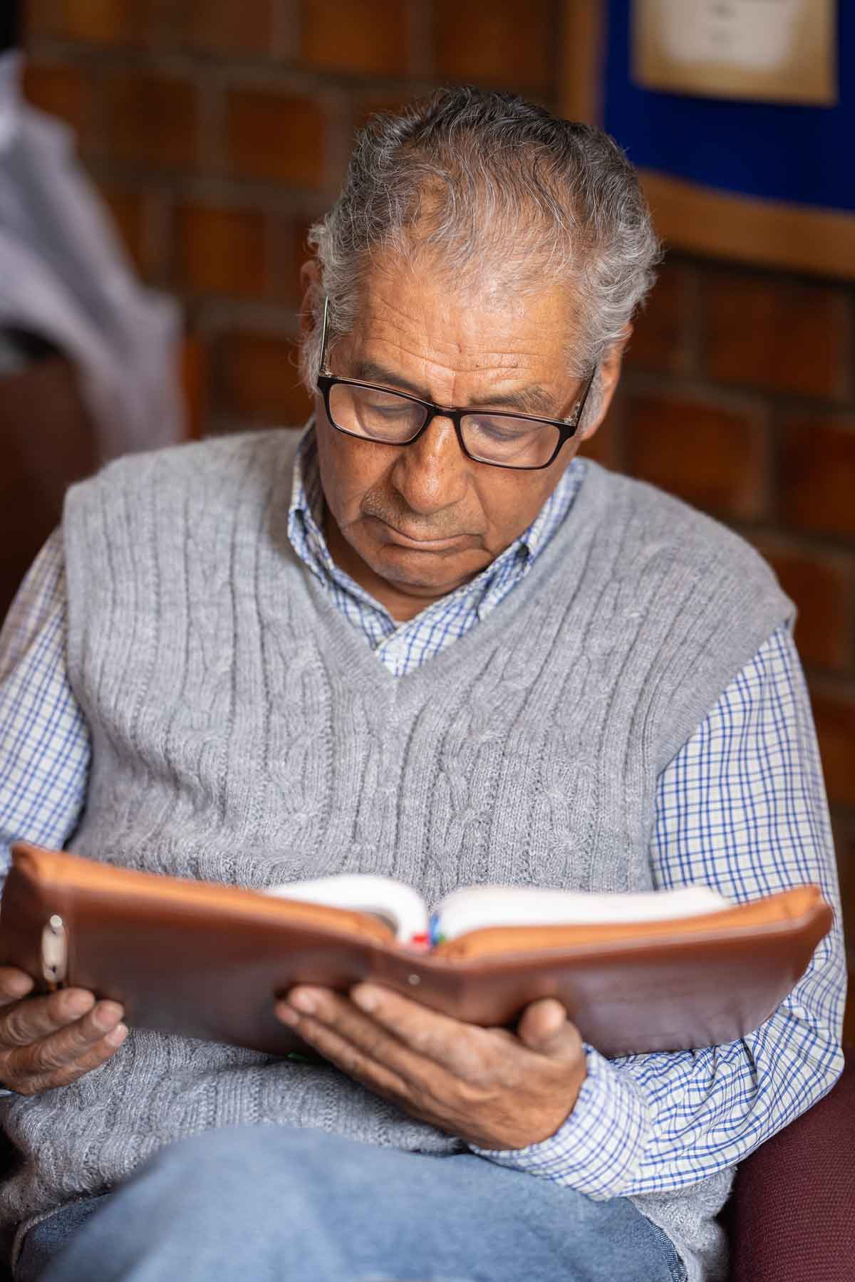 Leyendo la Biblia Un hermano sentado lee la biblia
